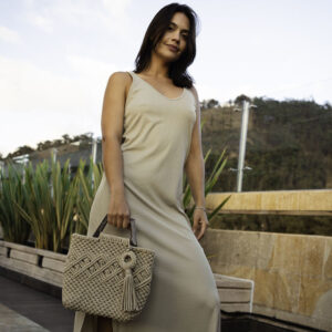 Mulher sentada com bolsa grande de macramê modelo Trancoso, estilo tote bag.