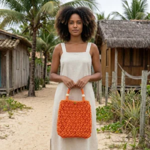 Bolsa de macramê laranja artesanal modelo Bahia usada com vestido claro